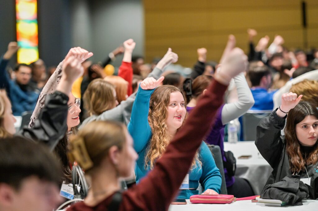 students at NGLA conference raising hands with thumbs up