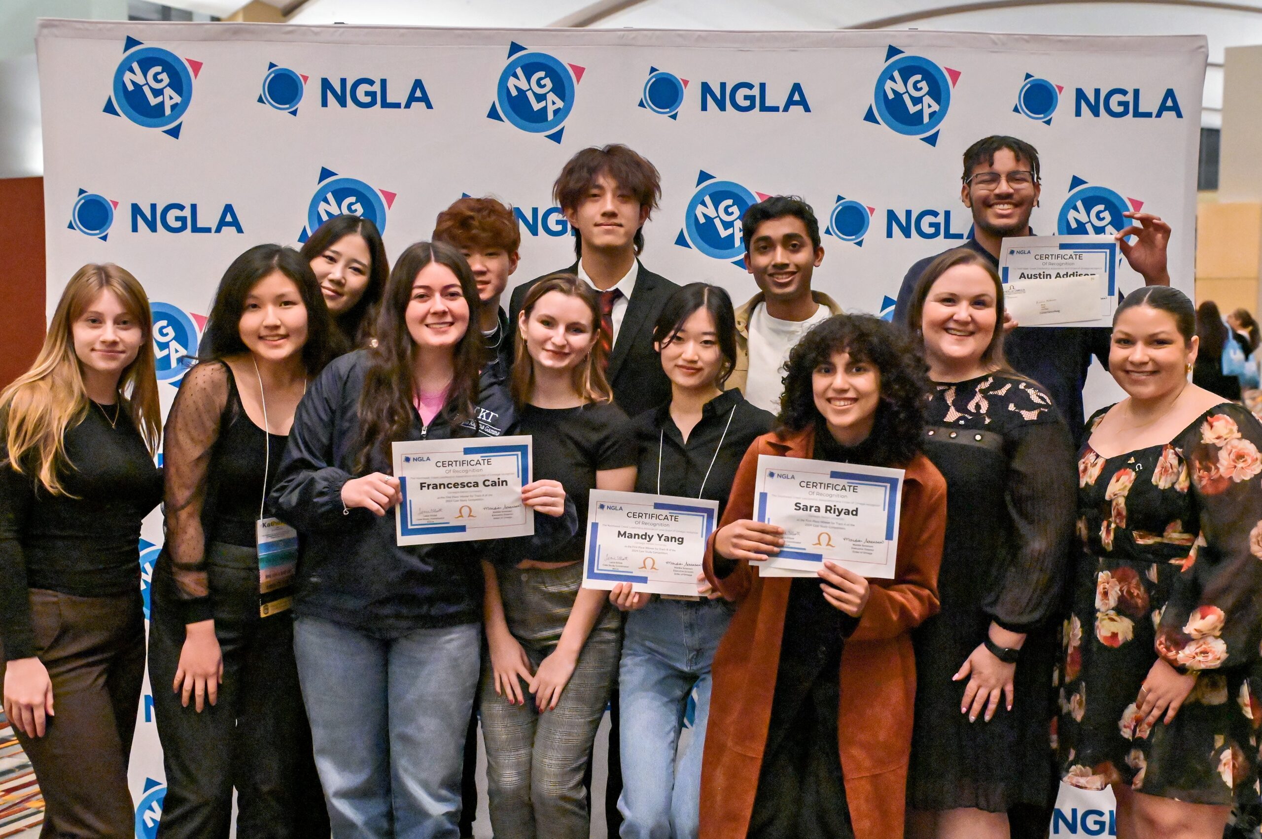 group of college students looking at camera with some holding up certificates